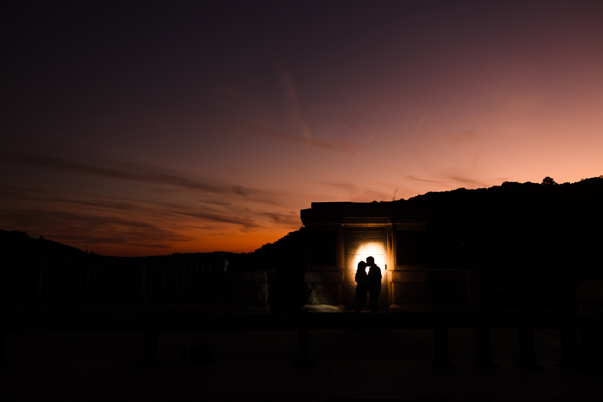 Silhouette of an engaged couple sharing a romantic kiss at sunset during their Croton Gorge Park engagement session in the Hudson Valley.