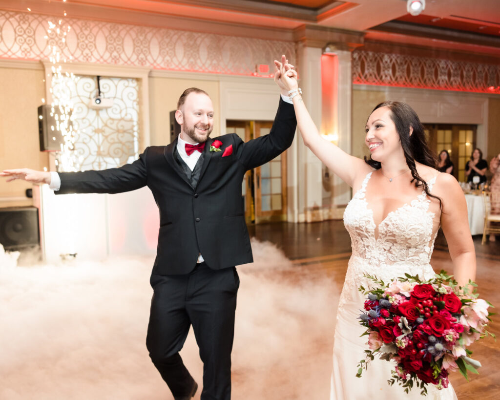 Bride and groom make a grand entrance at their Larkfield Manor wedding reception, surrounded by sparklers and elegant lighting in East Northport, Long Island.