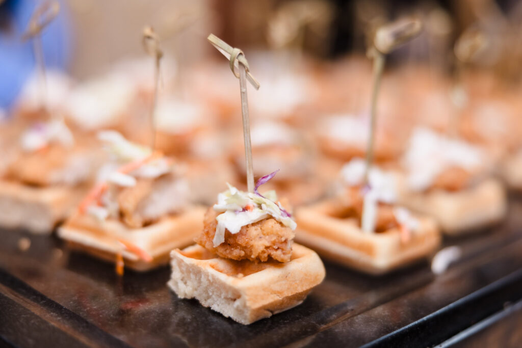 Mini chicken and waffle appetizers served at a wedding reception, showcasing elegant catering presentation on Long Island.