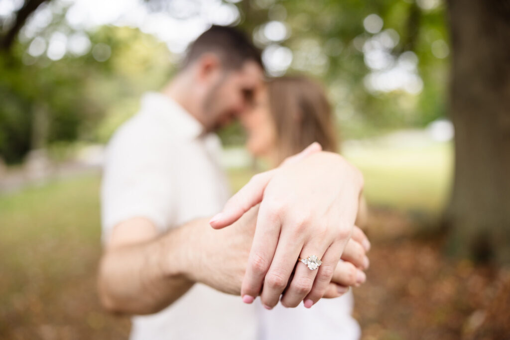 Close-up of engagement ring as couple embraces during their romantic fall engagement session.