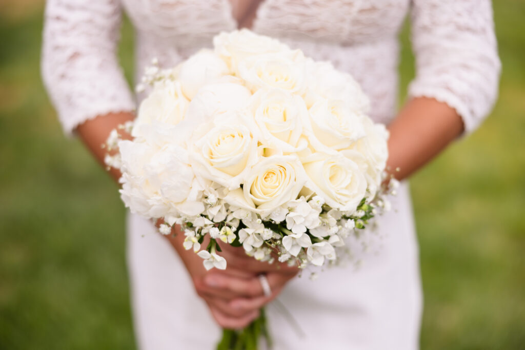 Bride holding a classic white rose and hydrangea bouquet before her elegant waterfront wedding at The Snapper Inn in Oakdale, Long Island.