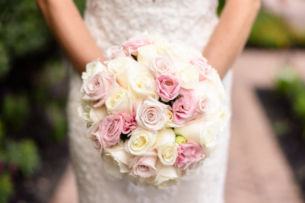 Close-up of bride holding a romantic pastel wedding bouquet with blush and ivory roses at Larkfield Manor summer wedding.