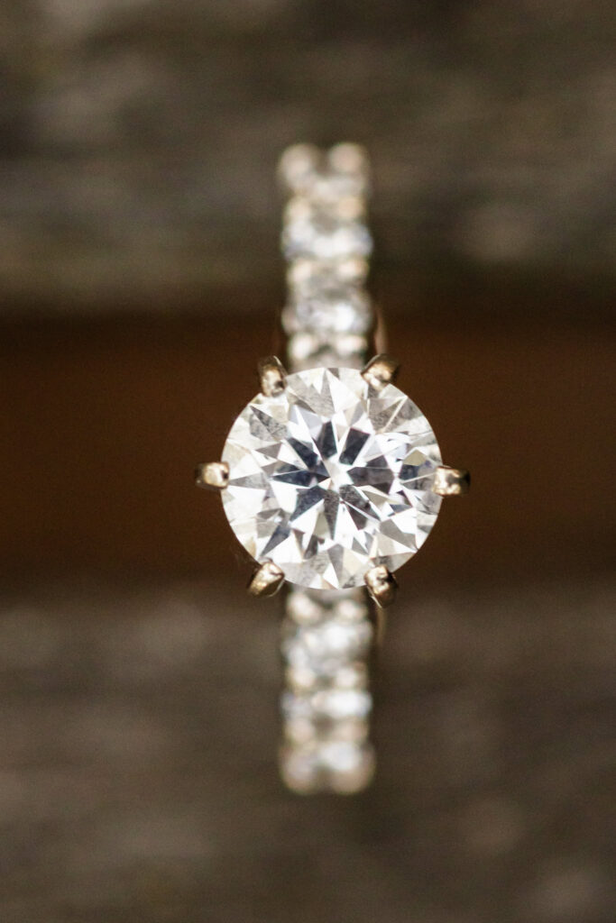 Close-up of a sparkling diamond engagement ring with a pavé band, beautifully displayed during a engagement session.
