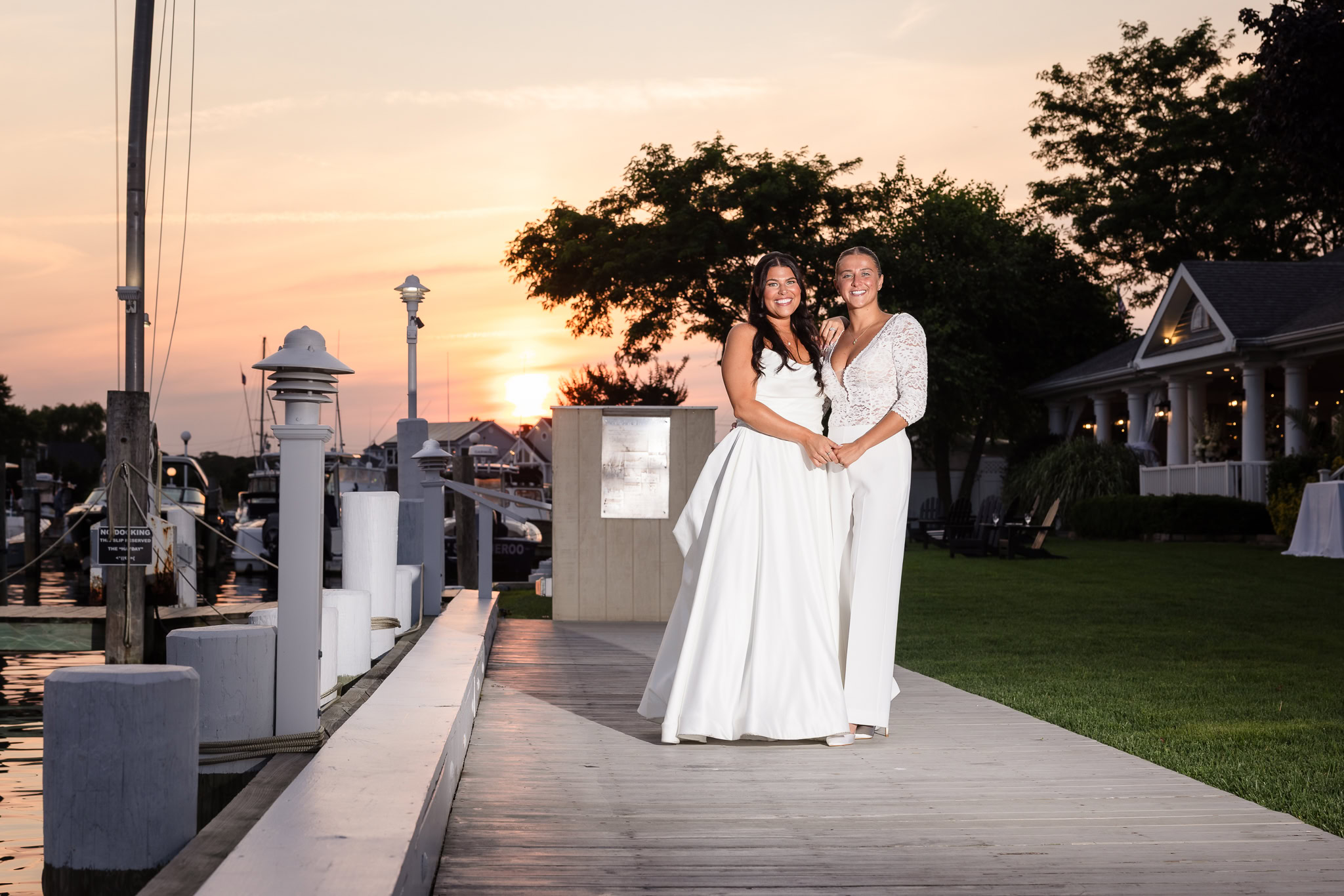 Brides standing together on the dock at The Snapper Inn during a romantic sunset, with boats and waterfront views in the background.