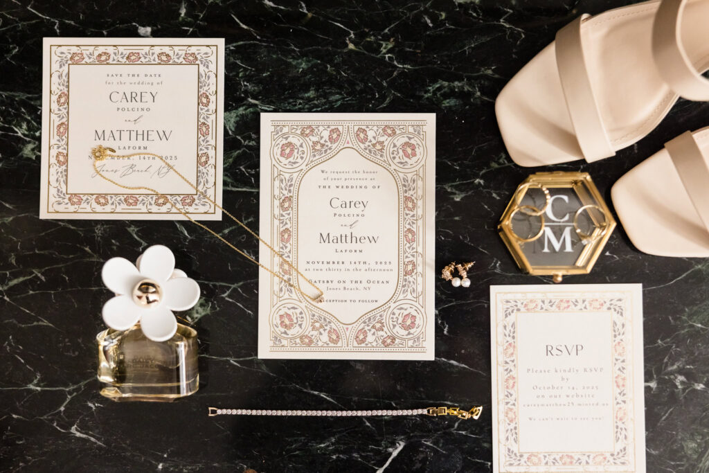 Flat lay of wedding details including invitations, rings, shoes, jewelry, and perfume for Carey and Matt's celebration.