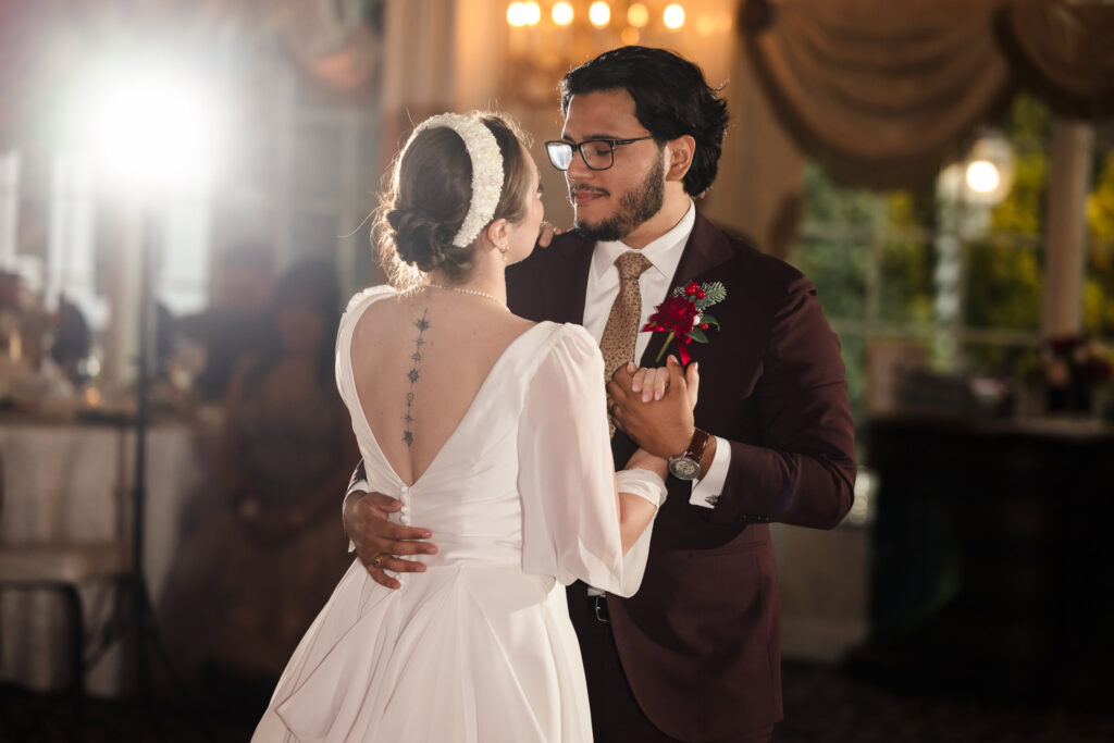 Bride and groom sharing their first dance at Giorgio’s Baiting Hollow, gazing at each other with warm lighting and romantic ambiance.