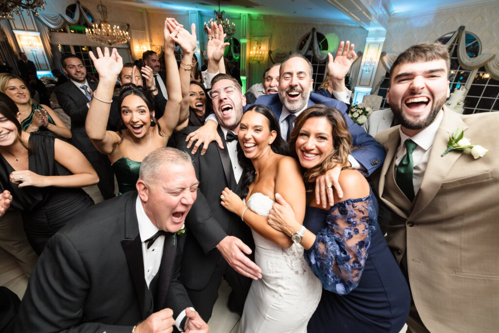Bride and groom celebrating on the dance floor surrounded by joyful guests during their wedding reception at Giorgio’s Baiting Hollow.