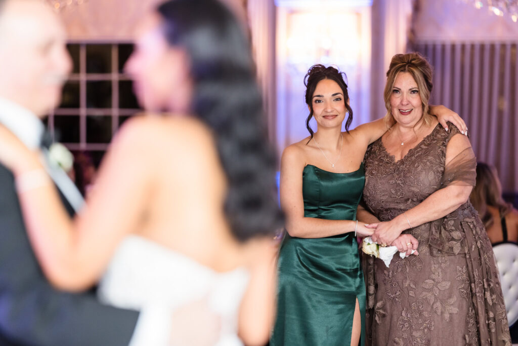 Mother and bridesmaid watch with emotion as the bride shares a special dance with her father during the reception at Giorgio’s Baiting Hollow, capturing a moment of legacy and love.