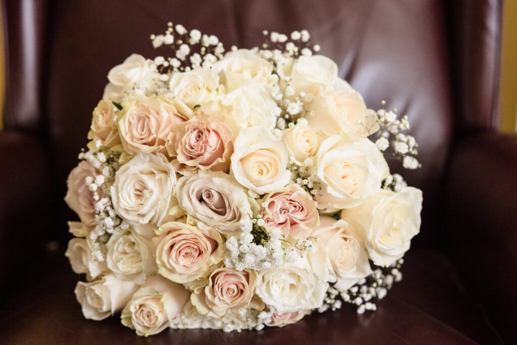 Elegant bridal bouquet featuring ivory and blush roses with baby’s breath, captured before Tellers Next Door wedding ceremony.