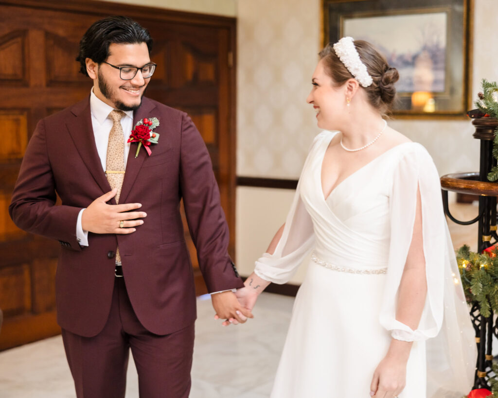 Bride and groom sharing an emotional first look near the staircase at Giorgio’s Baiting Hollow, holding hands and smiling in their winter wedding attire.