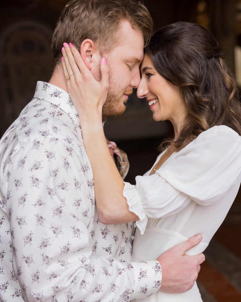 Close-up of engaged couple touching foreheads and smiling softly under the arches of Bethesda Terrace during their spring engagement session in Central Park.