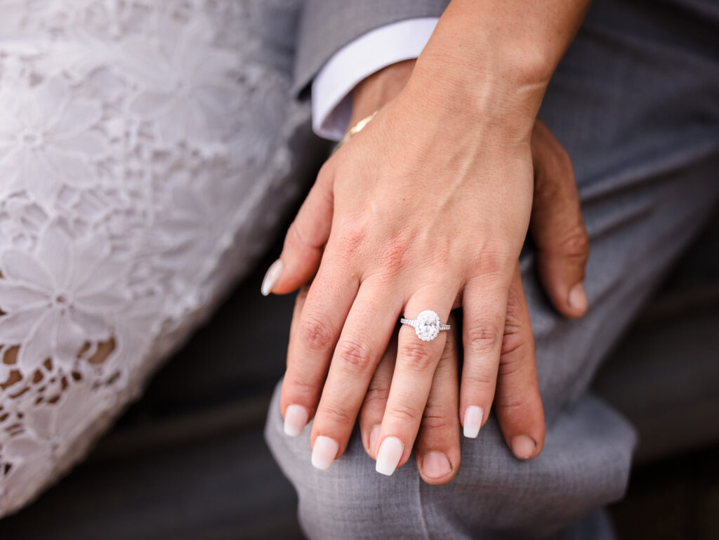 Close-up of engagement ring on bride-to-be’s hand resting over fiancé’s, capturing refined details during their editorial engagement session in Central Park.