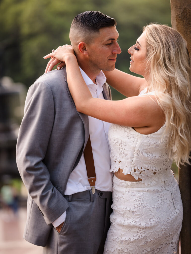 Engaged couple in a romantic embrace during their editorial engagement session in Central Park, with soft natural light and refined styling.