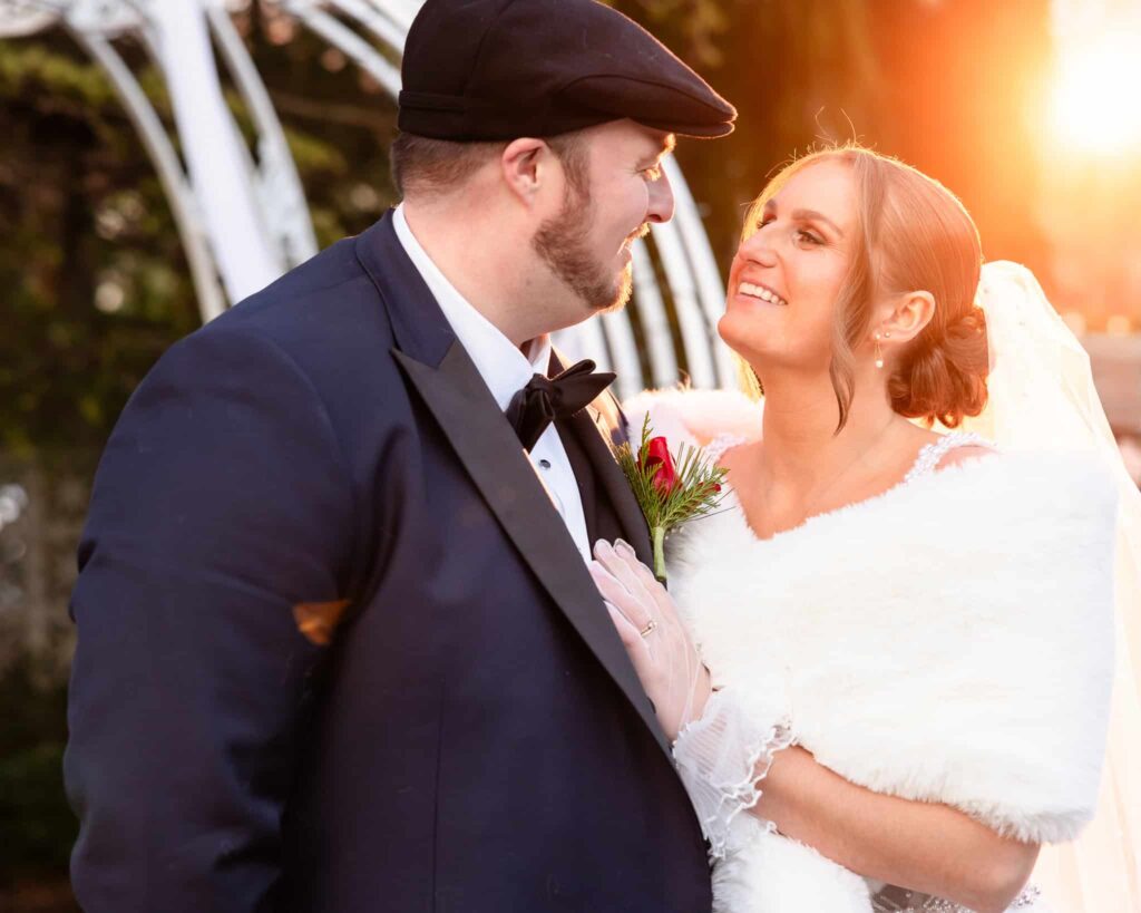 Sunlit winter portrait of the bride and groom at an Estate, sharing an intimate moment outdoors near the estate grounds on Long Island.