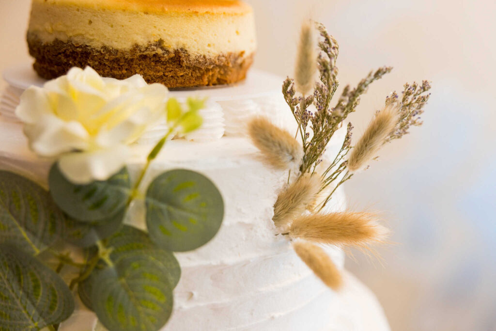 Wedding cake detail at an wedding reception, featuring a minimalist design with floral accents inside the elegant Long Island venue.
