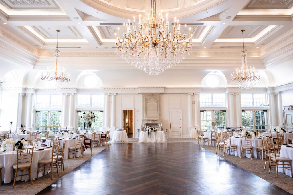 Grand ballroom at a Park Chateau wedding in East Brunswick, NJ, featuring crystal chandeliers, tall columns, and elegant reception tables at this luxury New Jersey wedding venue.
