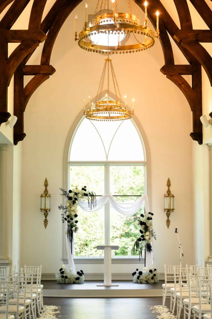 Indoor chapel ceremony space at Park Chateau Estate and Gardens wedding in East Brunswick, NJ, featuring arched windows, wood beams, and elegant floral altar design.