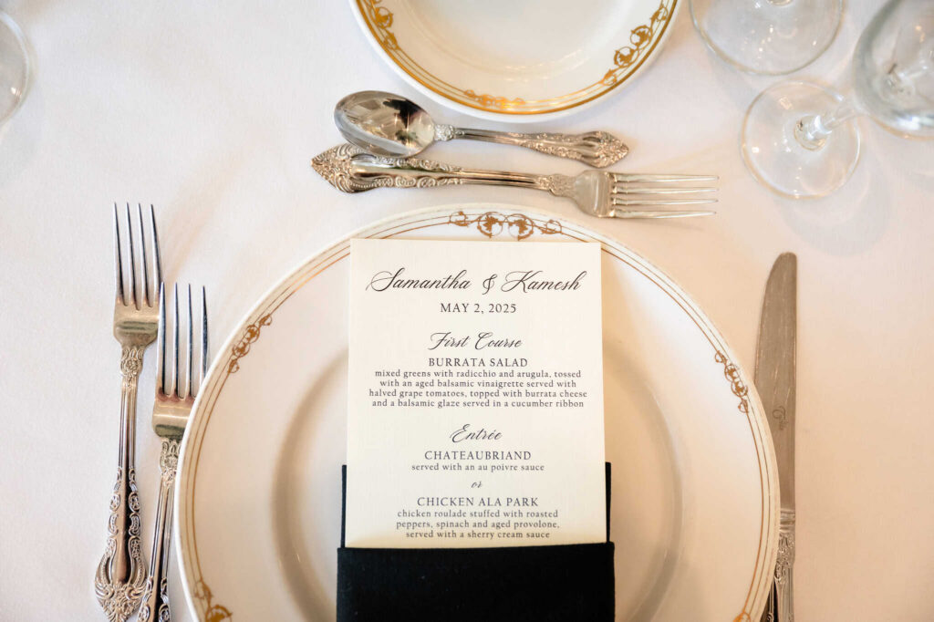 Elegant wedding menu and gold-rimmed china place setting at a wedding reception in East Brunswick, NJ, reflecting refined estate venue dining details.
