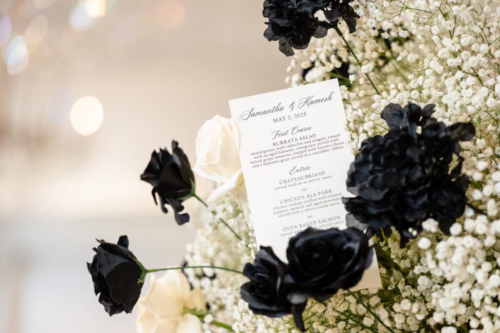 Black and white floral arrangement with wedding menu card at a Estate and Gardens wedding reception in East Brunswick, New Jersey.