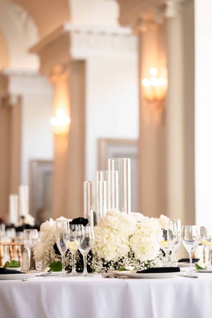 White hydrangea centerpiece and candle cylinders on reception table inside the ballroom, a refined East Brunswick NJ estate wedding venue.