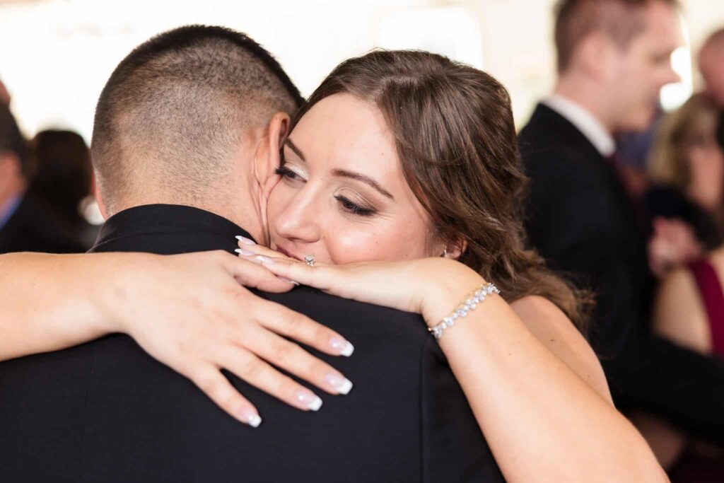 Emotional bride embraces groom during a heartfelt dance at their at wedding reception in Suffolk County.