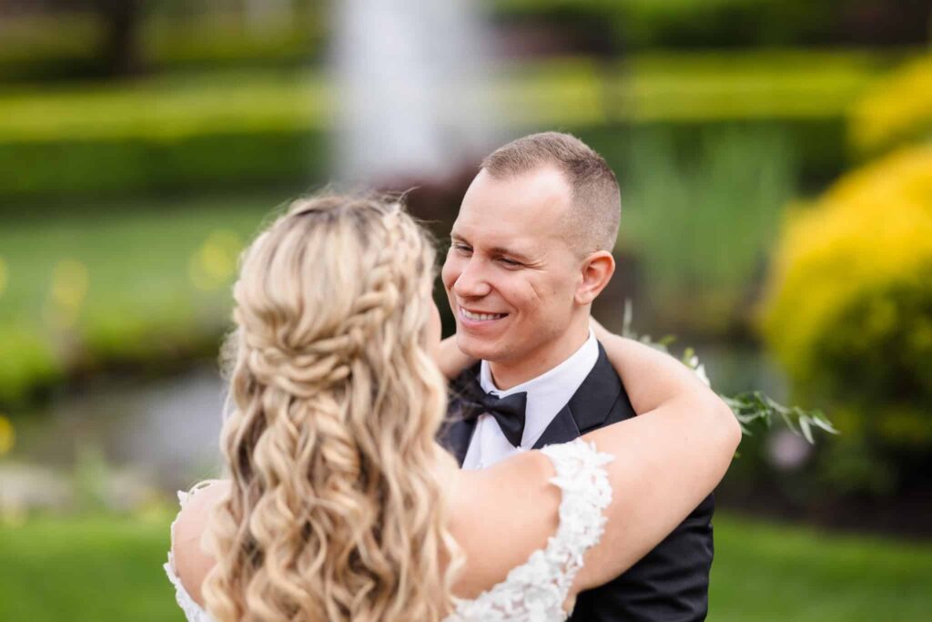 Groom smiling warmly at bride during an intimate moment in the garden.