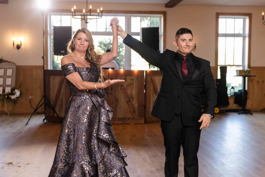 Groom dancing with his mother during the wedding reception at the Vineyard at East Wind, both smiling and celebrating.