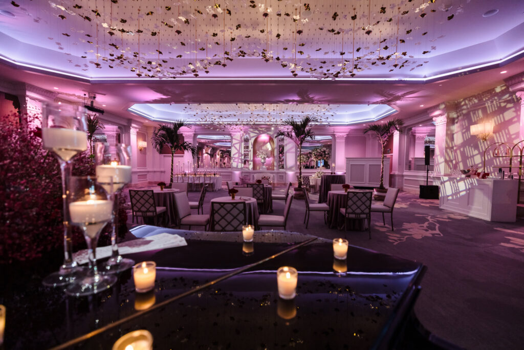 Wide view of the renovated Garden City Hotel ballroom with cocktail tables, blush uplighting, and sculptural ceiling installation during the Blush Hour wedding showcase.