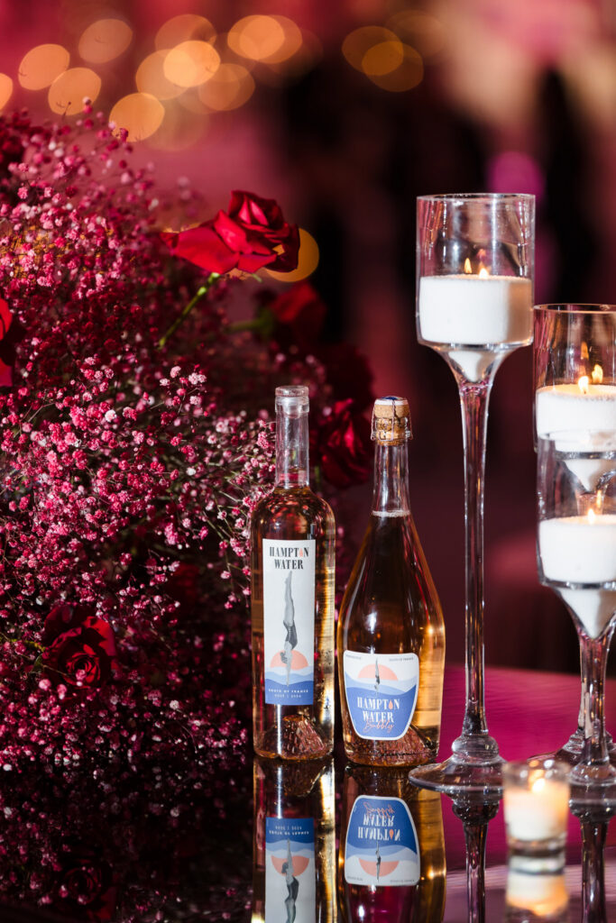 Romantic table vignette with red roses, candlelight, and Hampton Water rosé displayed during the Blush Hour wedding showcase at  NY.