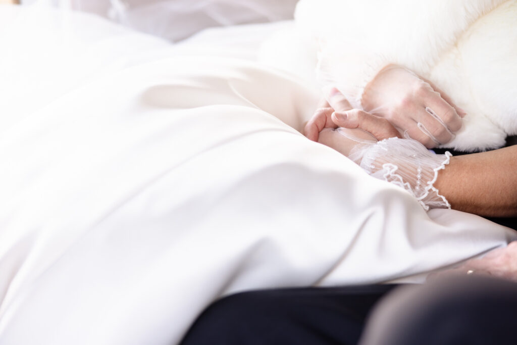 Close-up of a bride holding hands during a quiet, emotional wedding morning moment