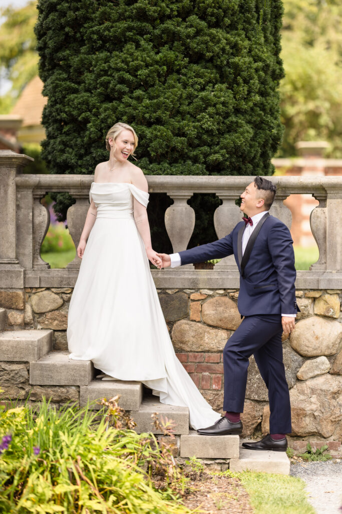 Joyful couple sharing a candid moment on garden steps during their wedding portraits