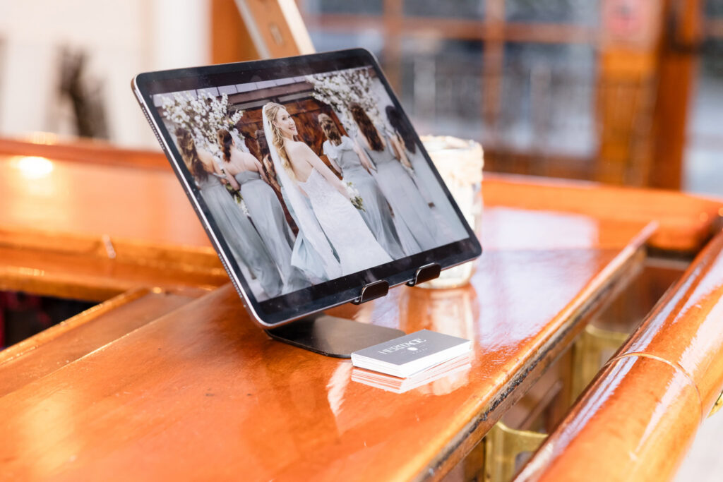 Digital wedding gallery preview displayed on a tablet during a luxury wedding reception.