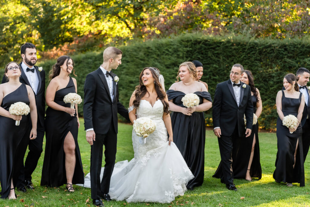 Bride and groom walking with their wedding party during an elegant outdoor Long Island wedding photography session