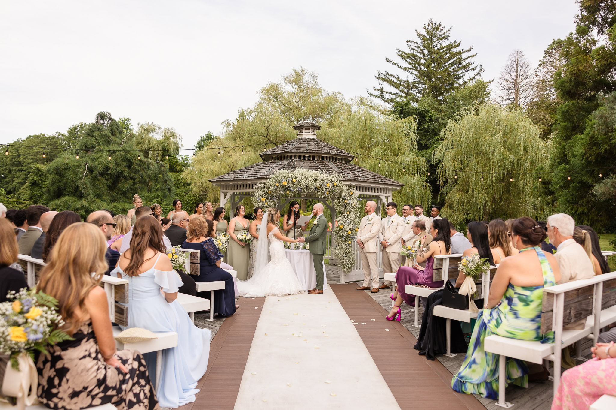 Outdoor wedding ceremony at Camp Pa-Qua-Tuck on Long Island with guests seated around a gazebo.