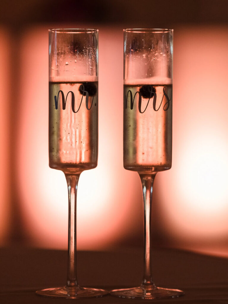 Personalized Mr. and Mrs. champagne flutes photographed during an elegant wedding reception.