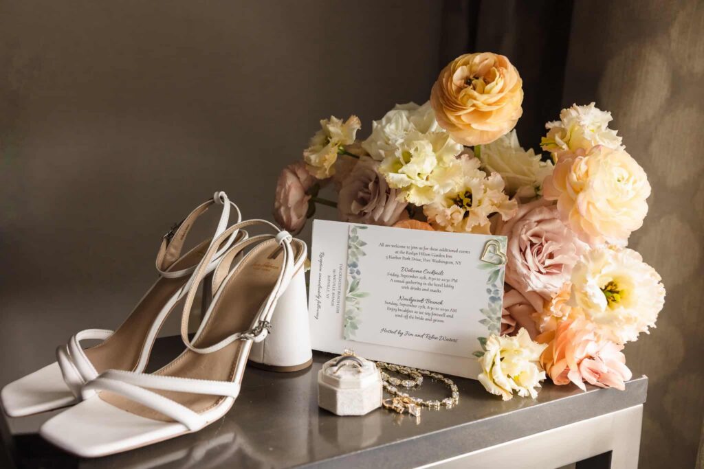 Long Island wedding photography details featuring bridal shoes, invitation suite, rings, and elegant floral styling.