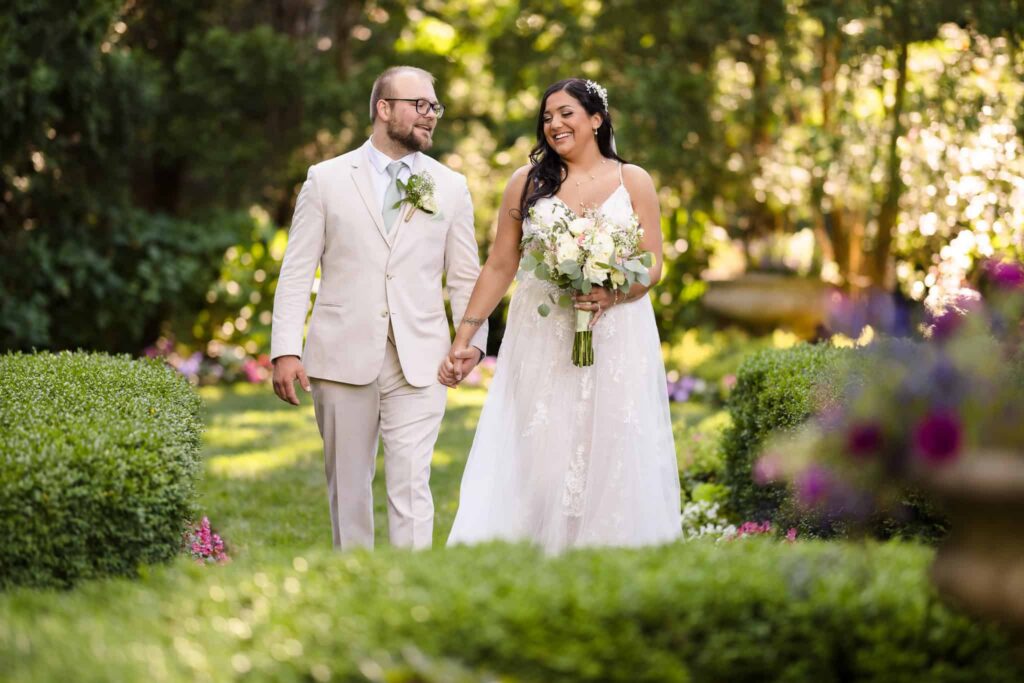 Experienced wedding photographer on Long Island capturing a joyful newlywed couple walking through the gardens at Flowerfield.