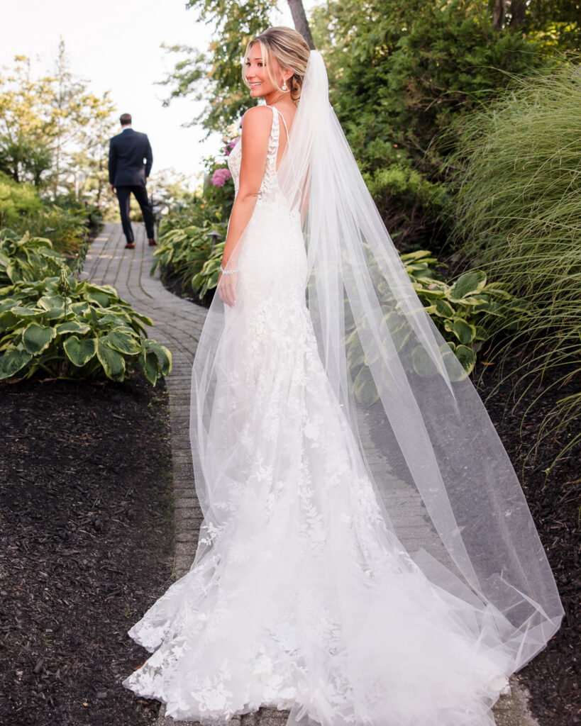 Bride smiling during an elegant bridal portrait session with flowing veil at a Long Island wedding venue