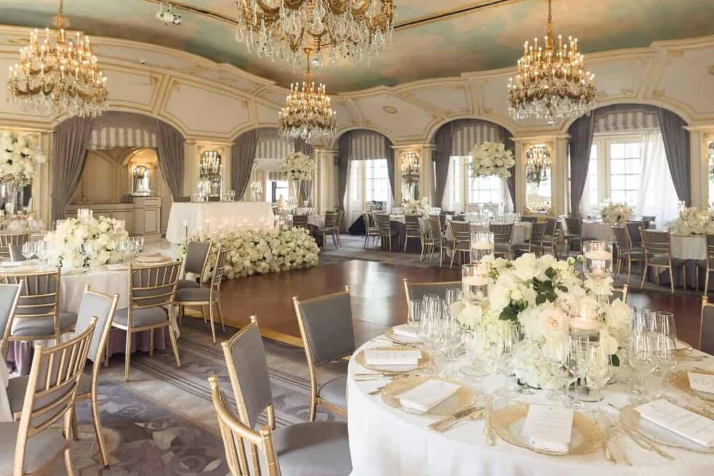Elegant ballroom wedding reception with crystal chandeliers, floral centerpieces, and refined table settings at a Long Island venue.