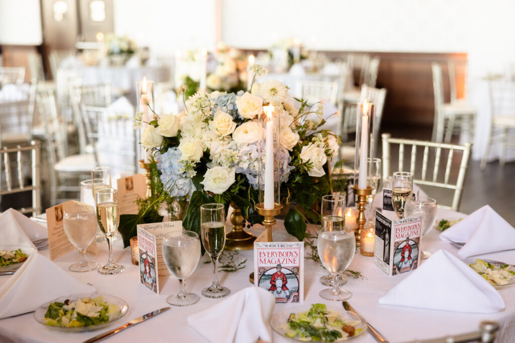 Reception table featuring period-inspired magazines, florals, and candlelight at a 1920s wedding on Long Island.