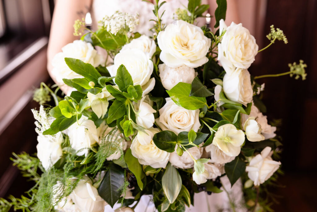 Garden-style bridal bouquet with white roses, greenery, and trailing foliage designed for a 1920s wedding on Long Island.