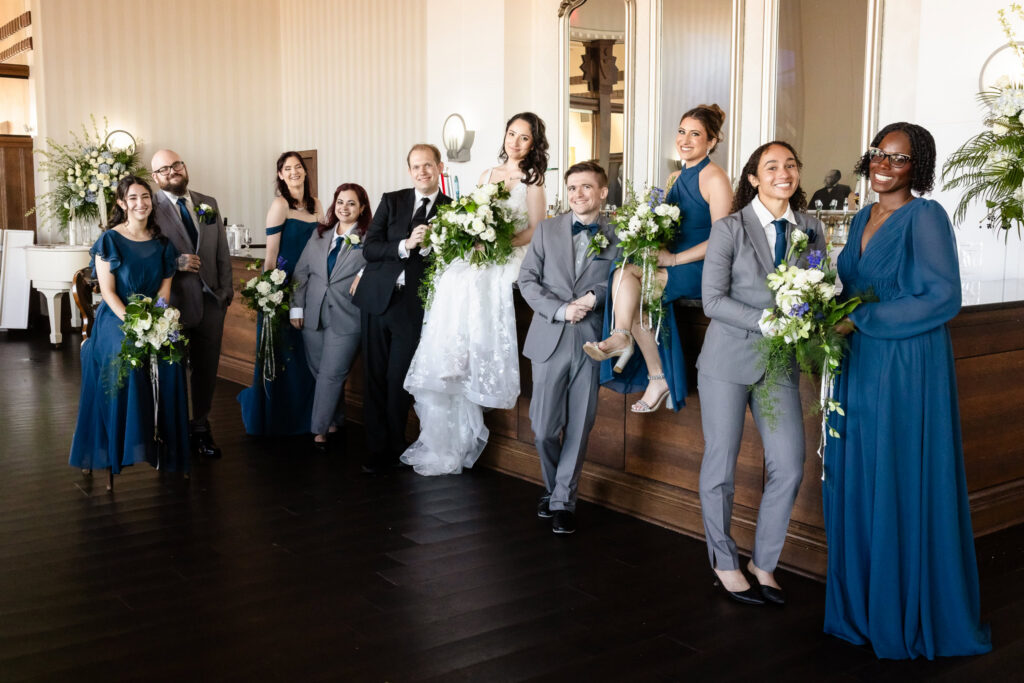Bride, groom, and wedding party posing together.
