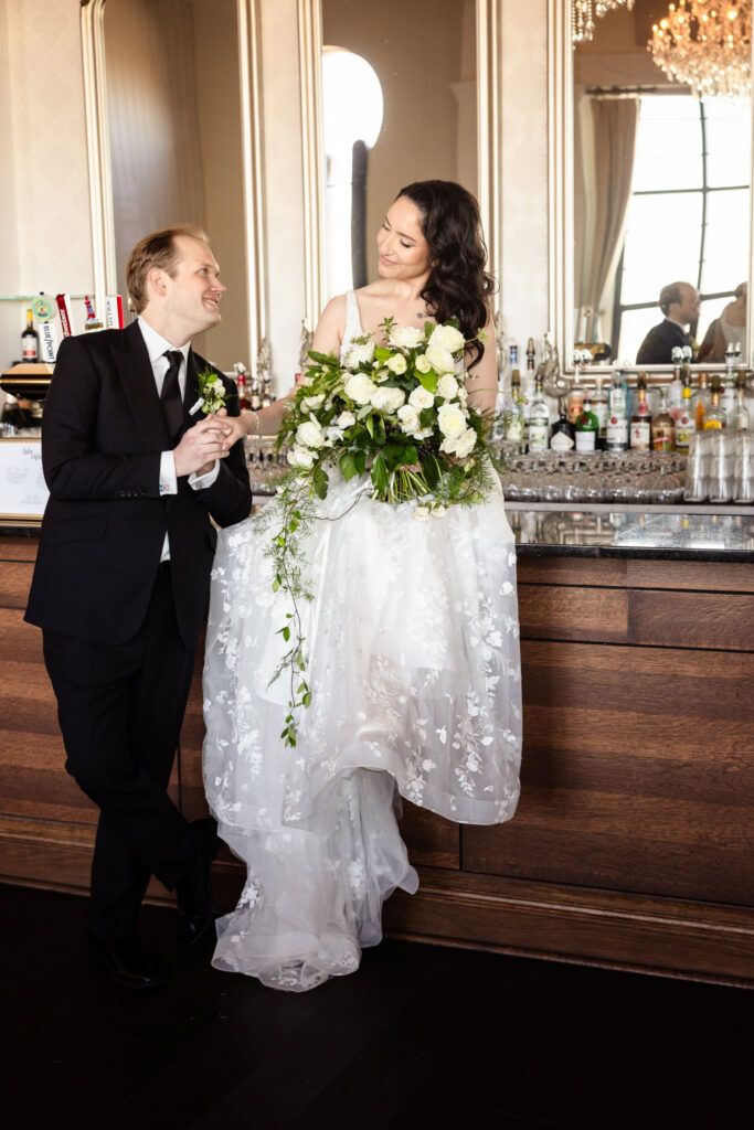 Bride and groom sharing a romantic moment at the bar during a 1920s wedding Long Island reception.