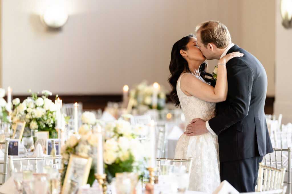 Bride and groom sharing a romantic kiss among elegant reception décor during a 1920s wedding Long Island celebration.