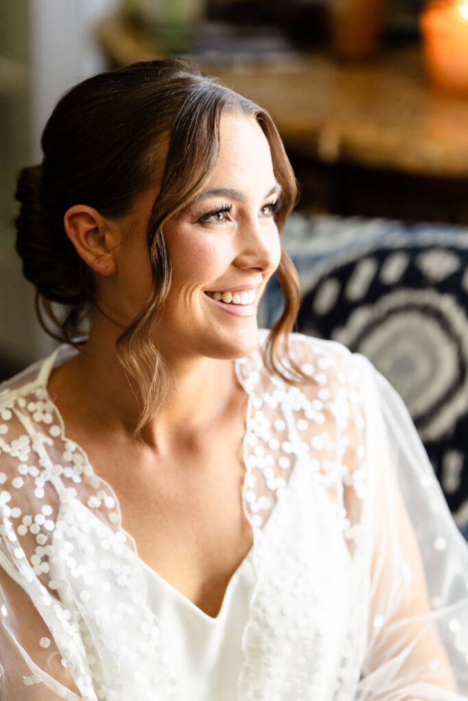 Bride smiling after reading a heartfelt letter during wedding morning preparations before her Heritage Club wedding.