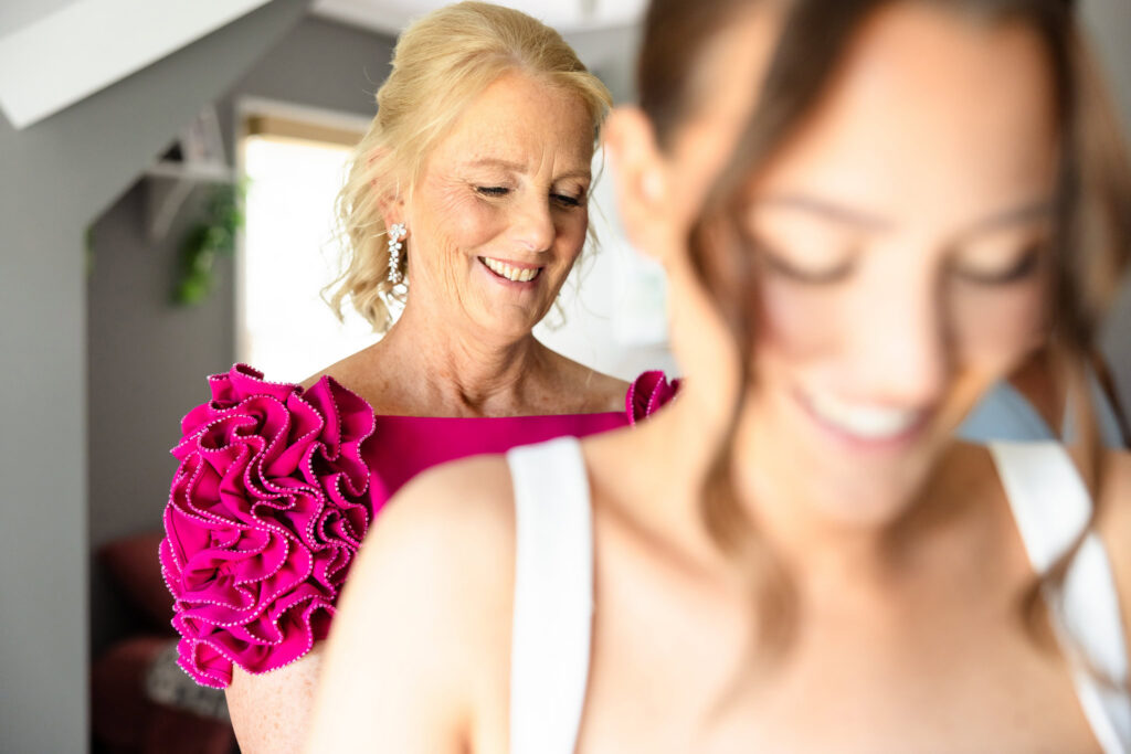 Ashley's mother smiles as she helps her daughter get ready on the morning of her Heritage Club wedding.