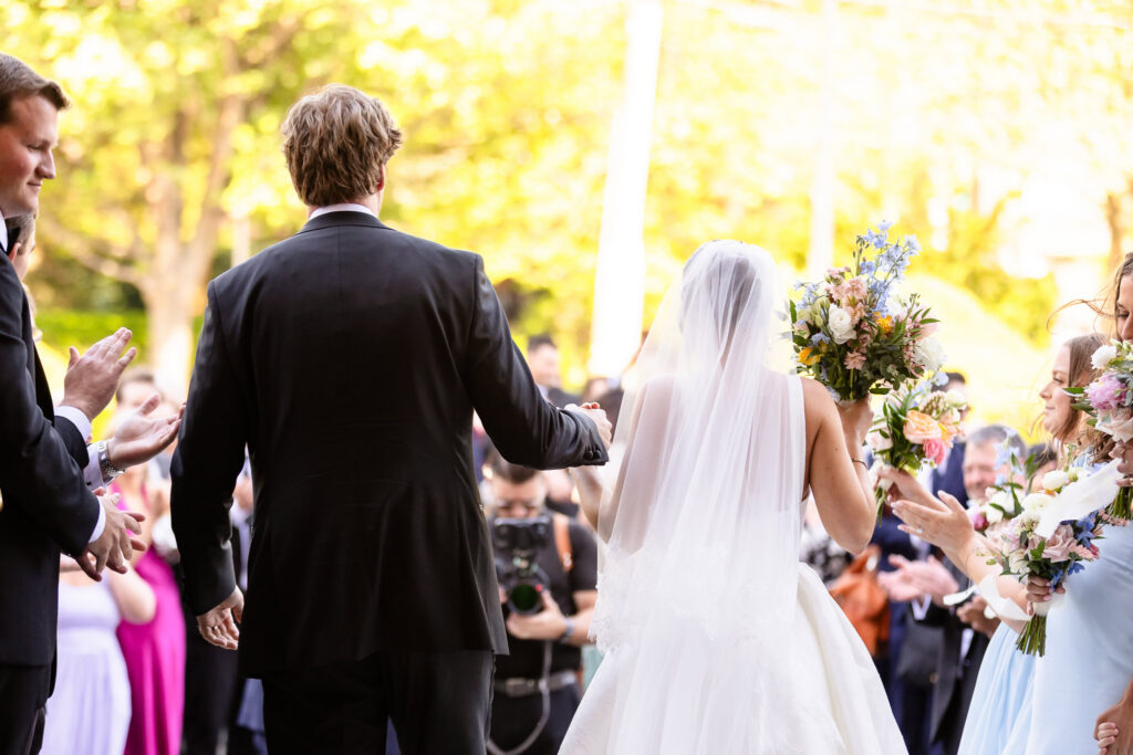 Ashley and Kyle walk down the aisle after their ceremony at St. Joseph's Church in Garden City as guests applaud.