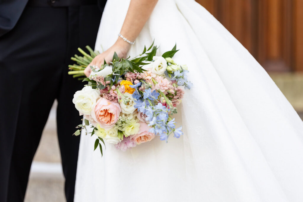 Ashley carries her pastel wedding bouquet outside St. Joseph's Church following the ceremony.