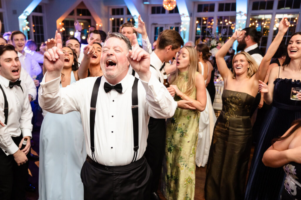 Wedding guests celebrate on the dance floor during Ashley and Kyle’s reception at The Heritage Club at Bethpage.