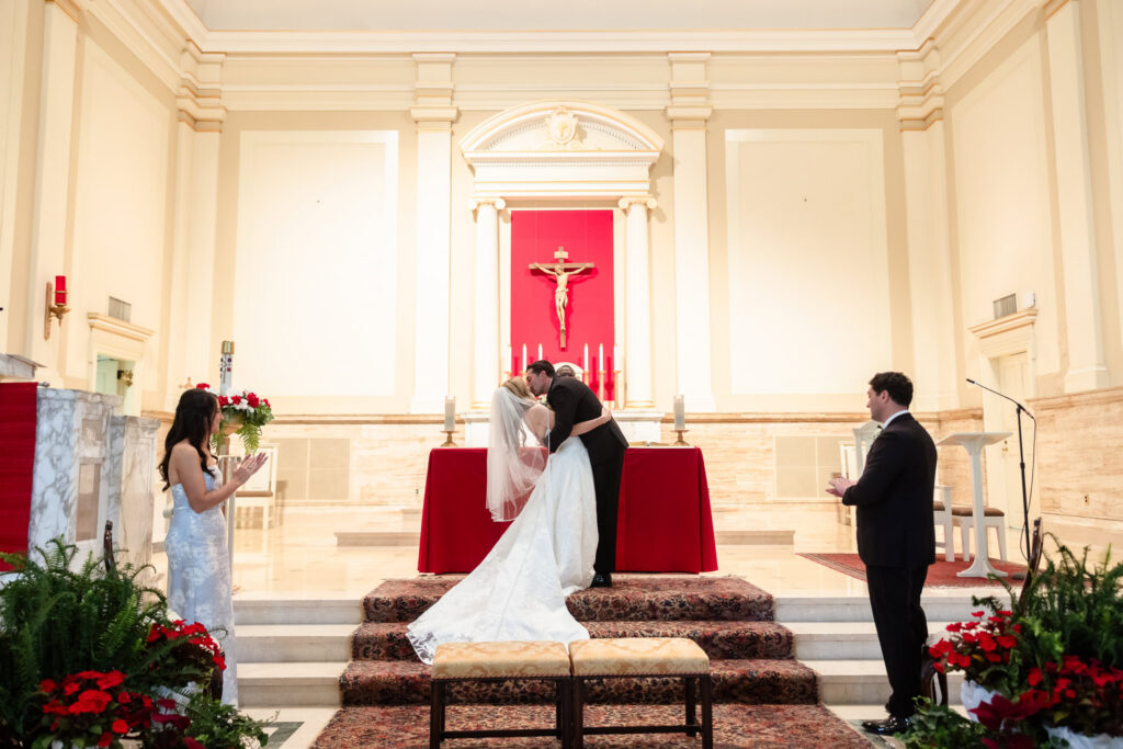 Bride and groom sharing their first kiss after exchanging vows before their Huntington Crescent Club wedding reception.